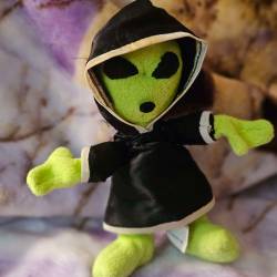 A green alien plush with a black hood