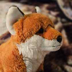 An image of a red fox plush facing to the side.